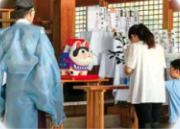 社殿内の祈祷。神職と犬張子、参拝する親子